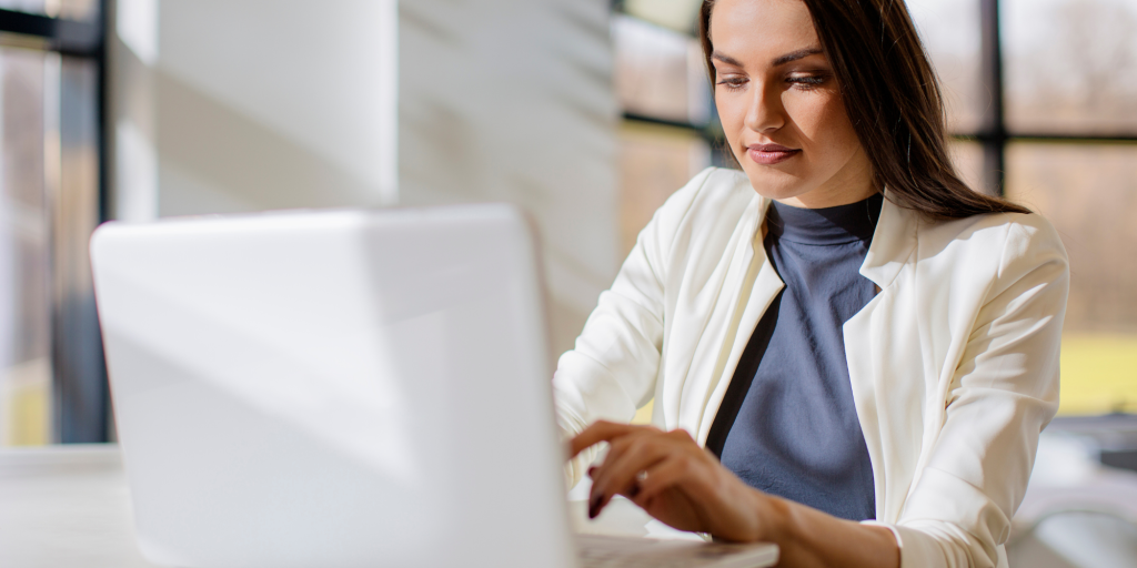 Une étudiante qui tape au clavier de son PC portable pour s'inscrire en DEUST Préparateur/Technicien en pharmacie