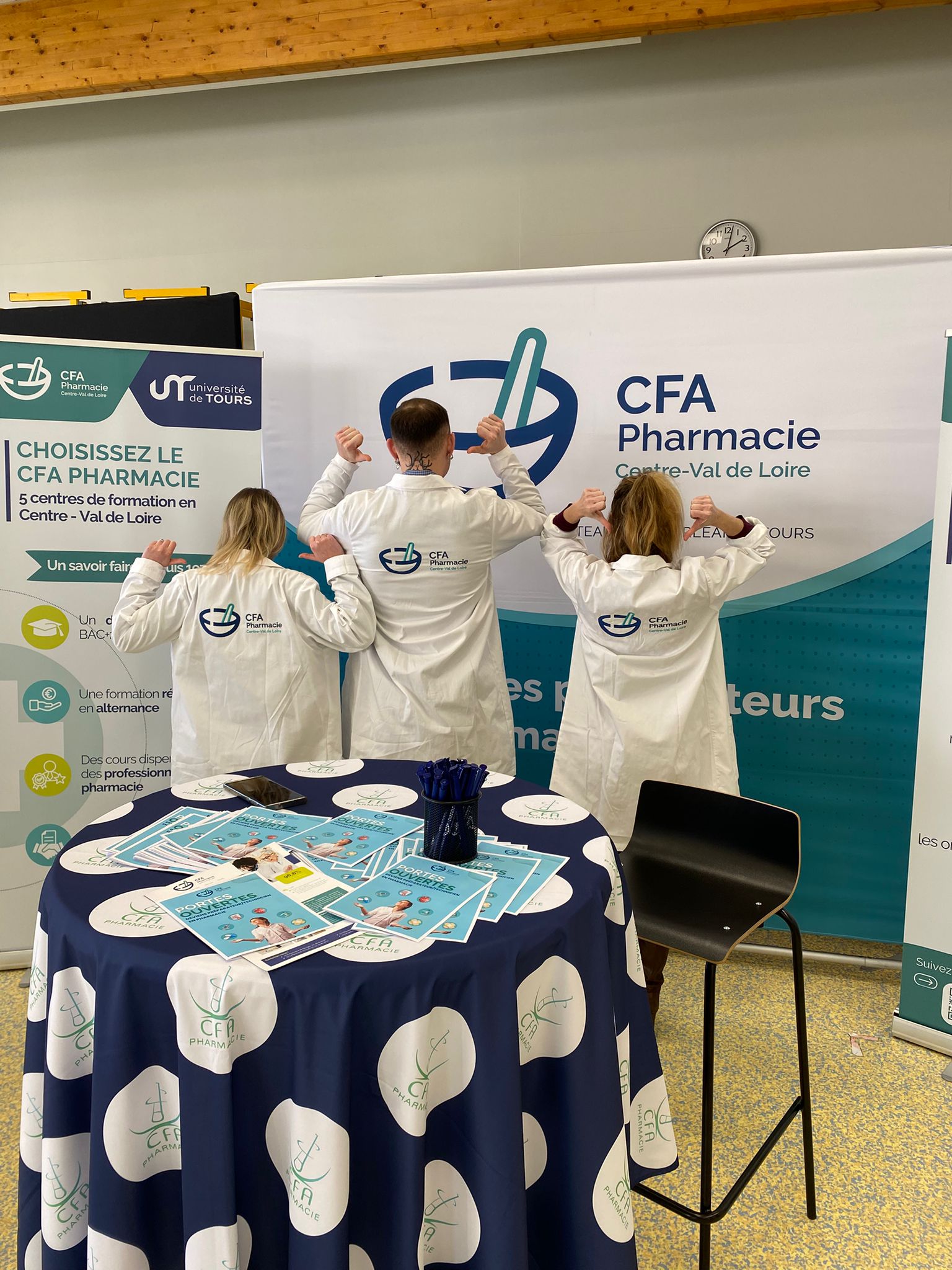 Étudiants du CFA Pharmacie en blouses blanches animant le stand du CFA lors d'un salon/forum.
